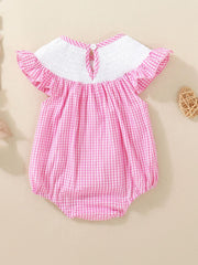 Pink gingham baby one-piece with smocked white bodice and ruffled sleeves.