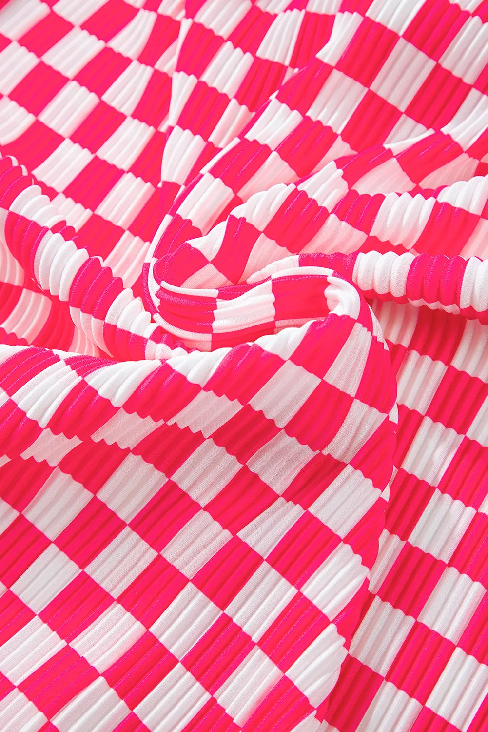Pleated lounge set fabric in pink and white checkered plaid pattern.