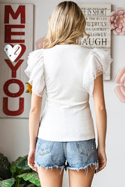 White ribbed knit blouse with sheer dot mesh puff sleeves.