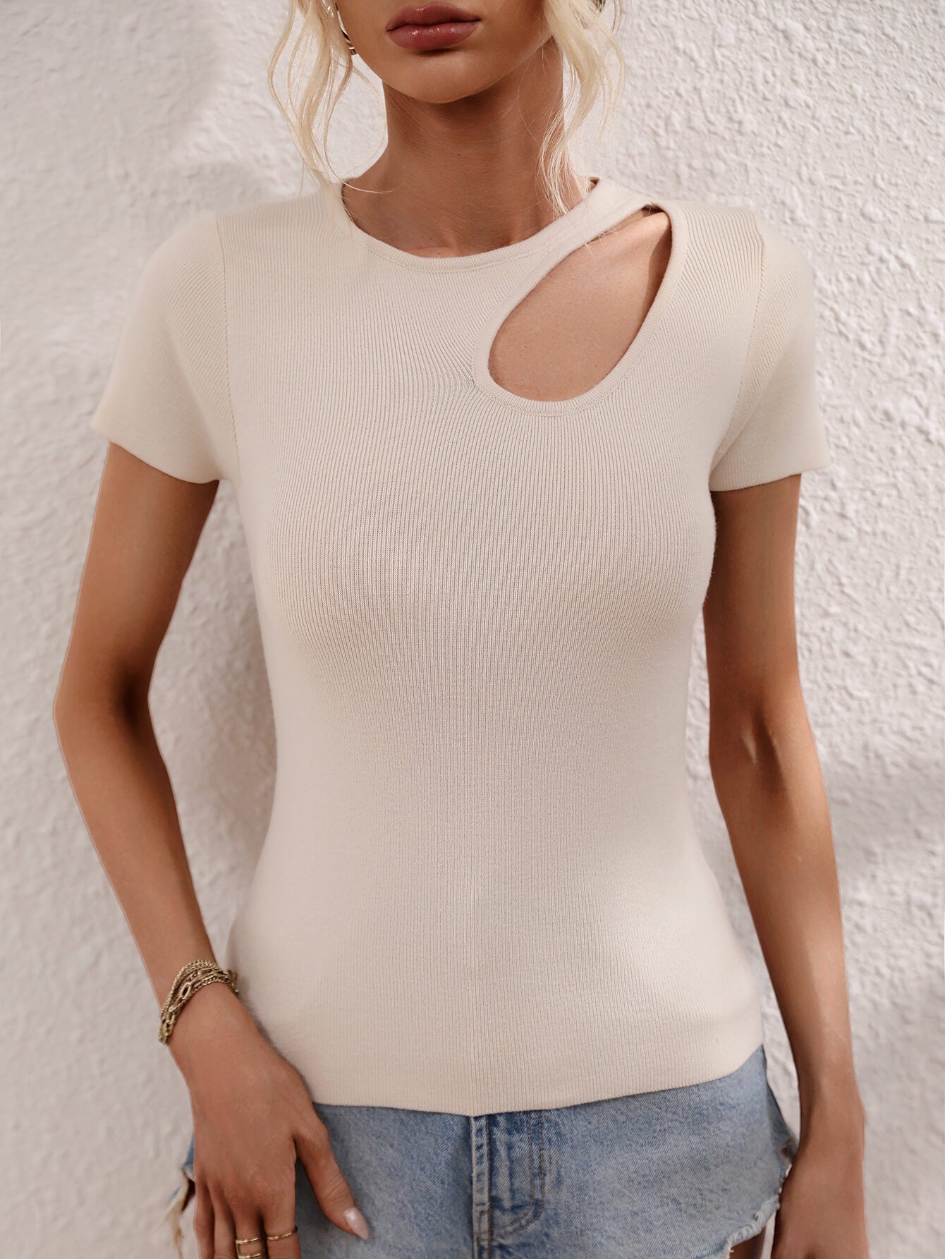 Cream knit t-shirt with short sleeves and a chic cutout detail on the neckline.