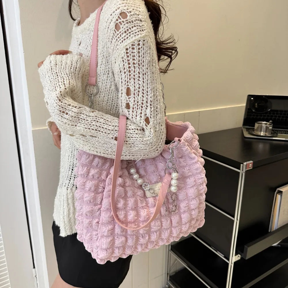 Textured grid pearl chain tote bag in blush pink with pearl and chain embellishments.
