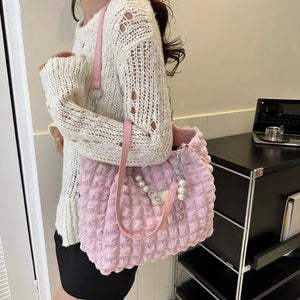 Textured grid pearl chain tote bag in blush pink with pearl and chain embellishments.