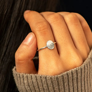 Silver band ring with engraved wave pattern on oval face