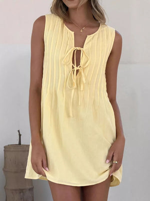 Yellow tie-front mini dress with vertical pintuck details and a keyhole neckline.