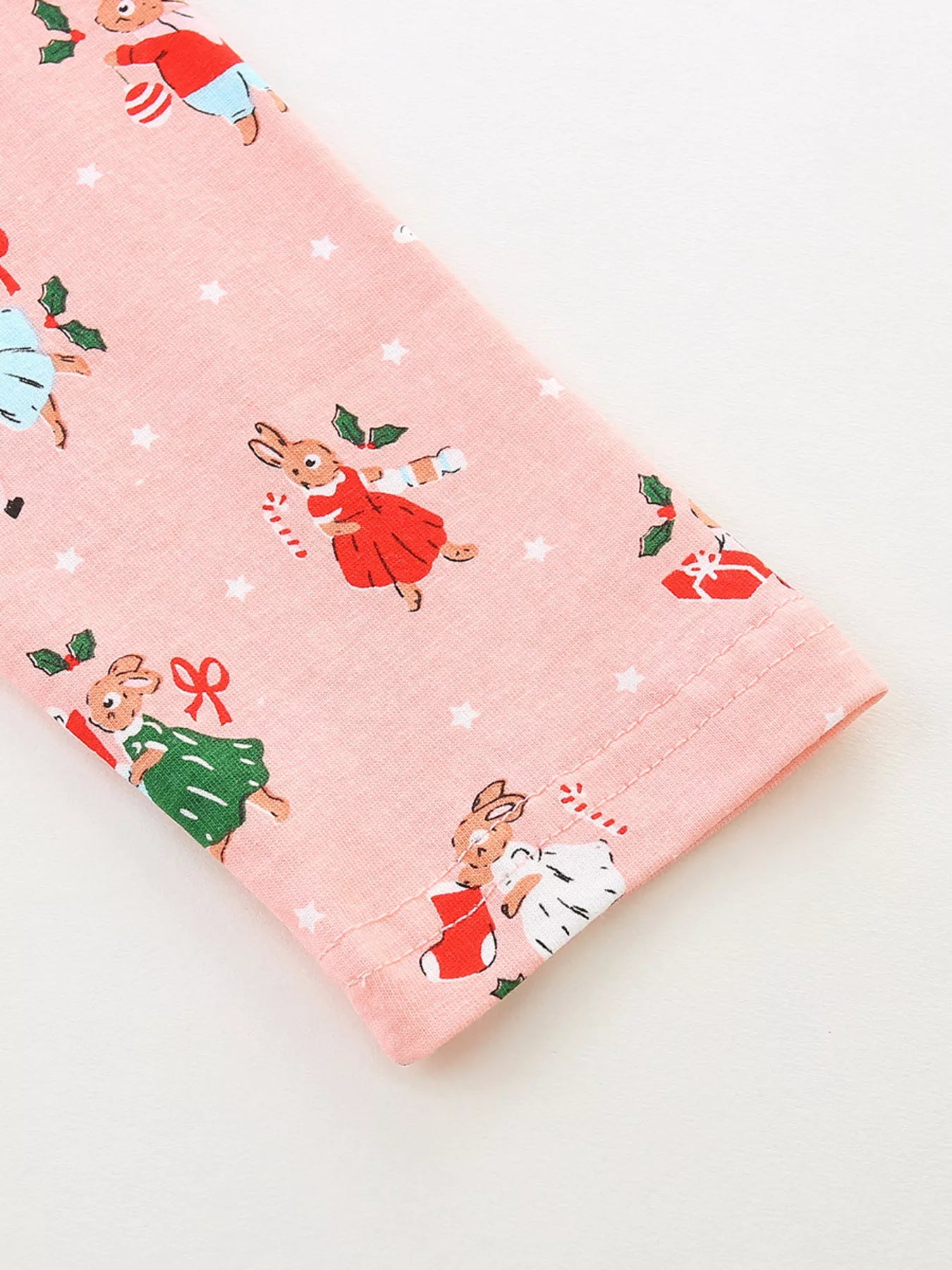 Pale blush cotton dress with a festive Christmas bunny print and white stars.
