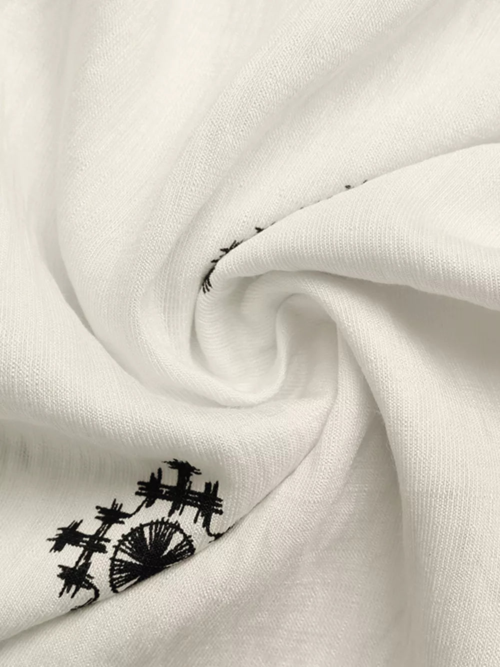 White midi dress with black geometric embroidery detail