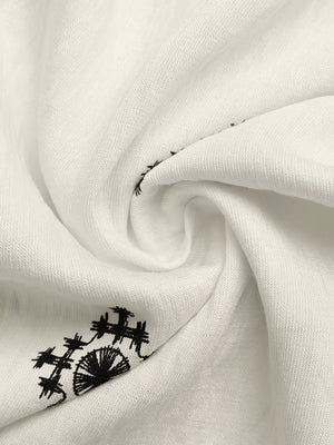 White midi dress with black geometric embroidery detail