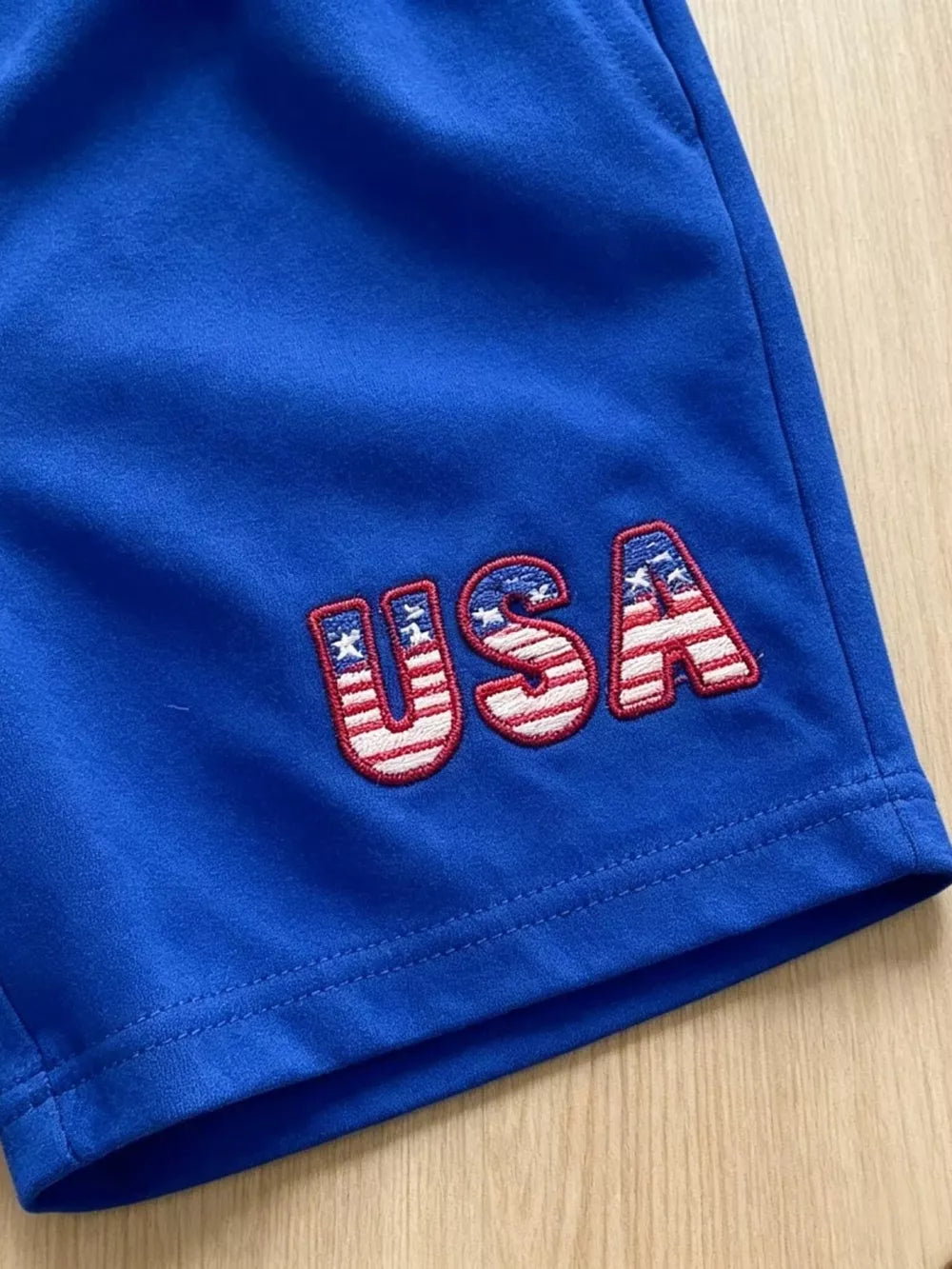 Blue baby shorts with embroidered USA flag letters
