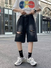 Black relaxed fit denim shorts with distressed knee rips and a frayed hem.