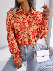 Floral print blouse in pumpkin with shirred cuffs and button front.