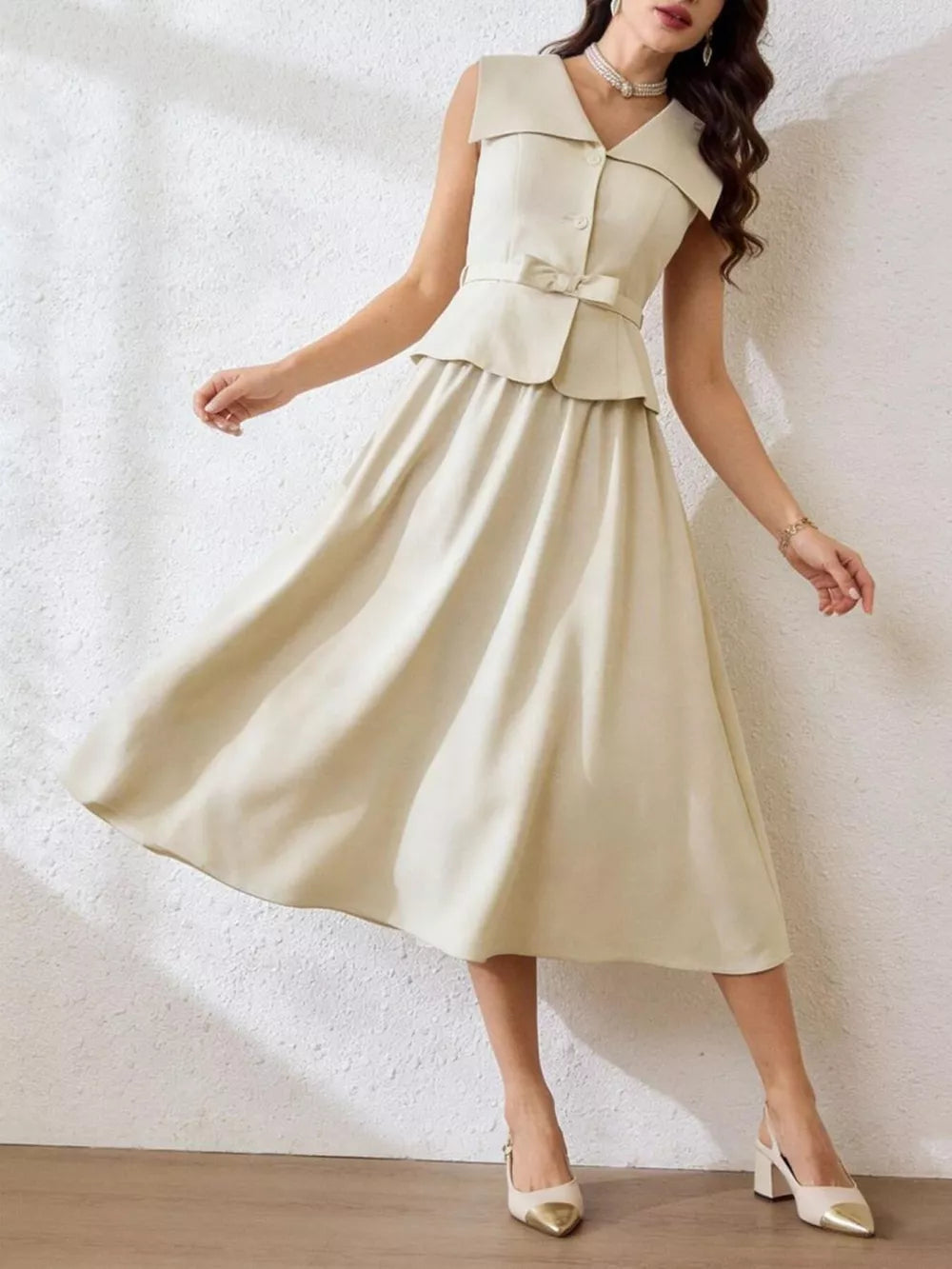 V-neck peplum top and midi skirt set in beige with a bow detail and button front.