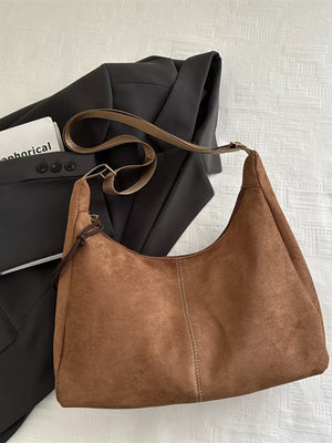 Brown suede crossbody bag with adjustable strap and contrast stitching