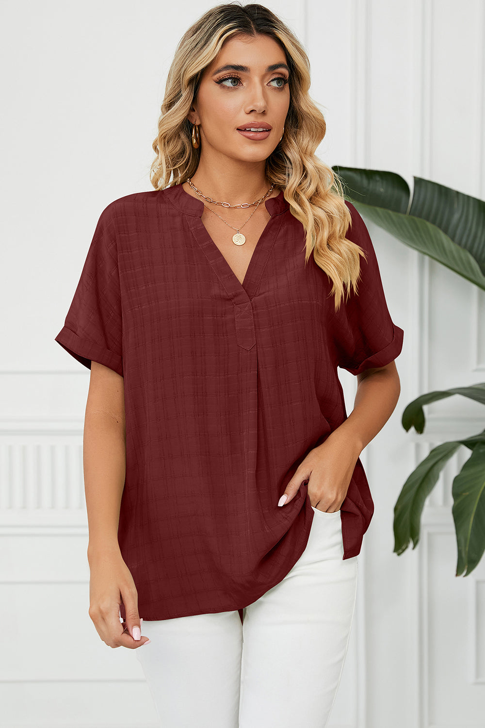 Burgundy blouse with V-neck, rolled short sleeves, and subtle plaid texture.