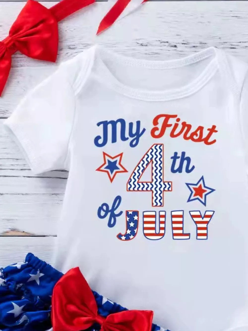 White baby onesie with "My First 4th of July" graphic and patriotic bloomer set.