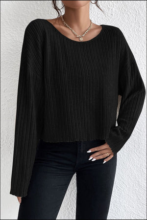 Black ribbed knit off-shoulder long sleeve crop top with a relaxed fit.