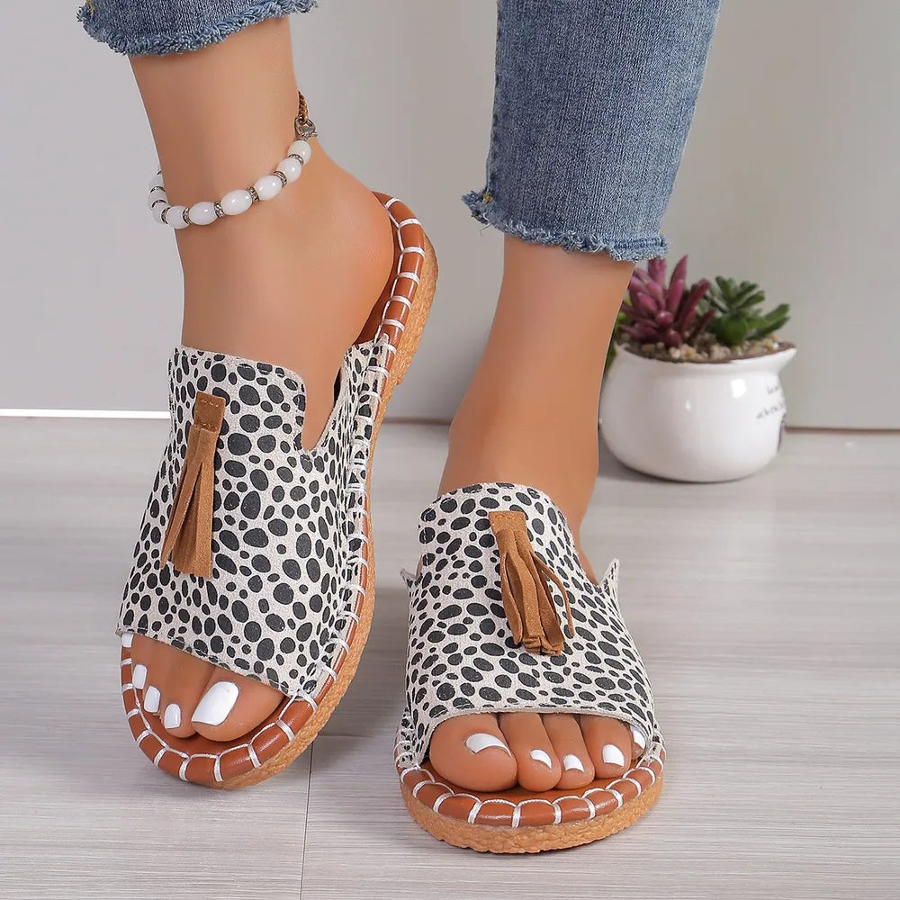 Spotted tassel slide sandals in mocha with open toe and tan trim.