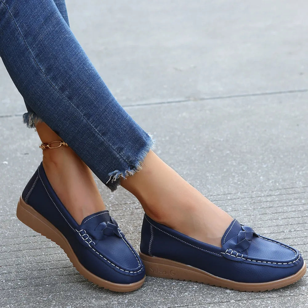 Dark blue leather loafers with braided detail and white stitching.