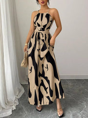 Chic halter neck maxi dress with abstract print in beige and black, belted waist, ankle length.