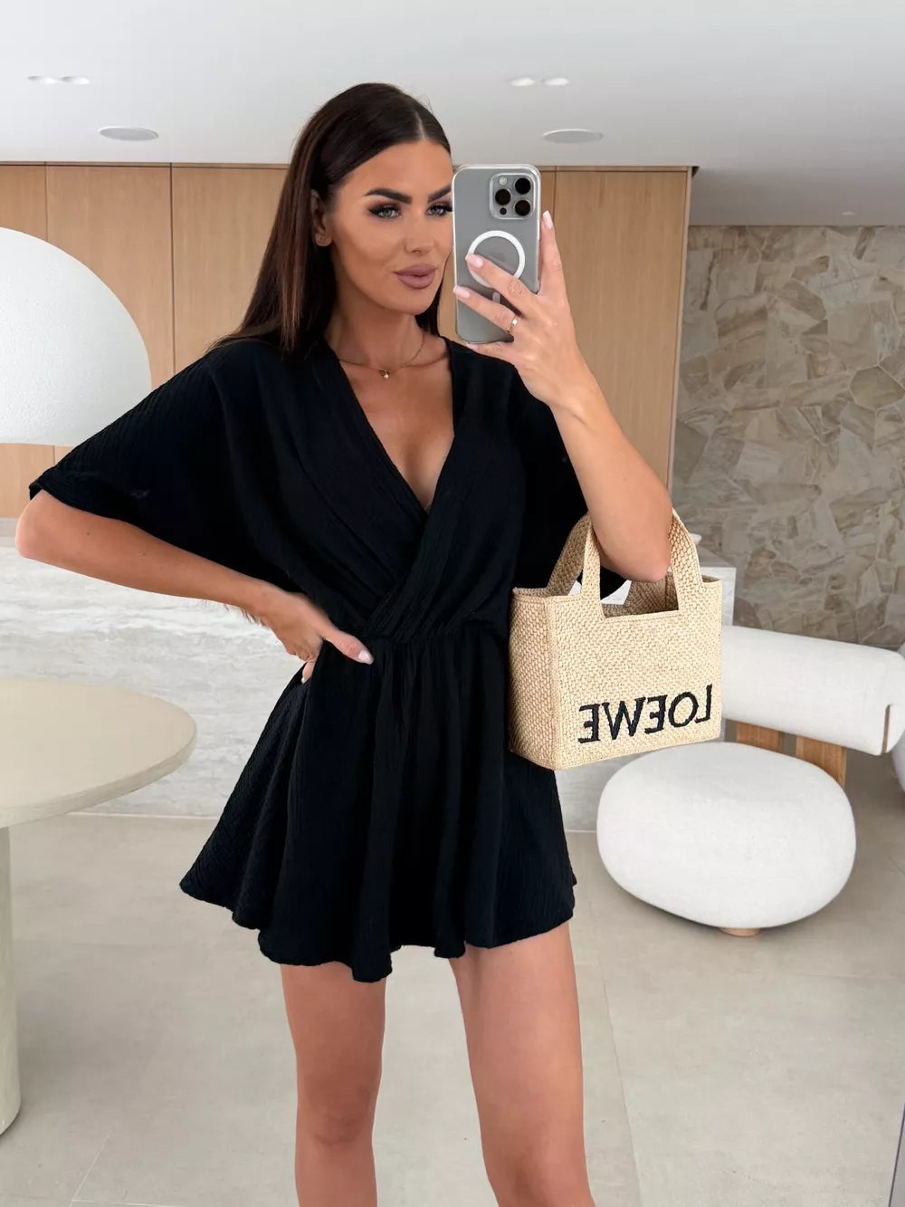 Black V-neck romper with dolman sleeves and cinched waist detail