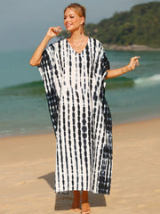 Black tie-dye maxi kaftan dress with vertical stripes and V-neck, worn on the beach.