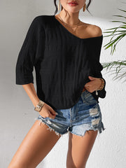 Black textured knit dolman sleeve top with a V-neck, styled with denim shorts.
