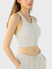 Ivory zip-front racerback sports bra with a cropped fit.