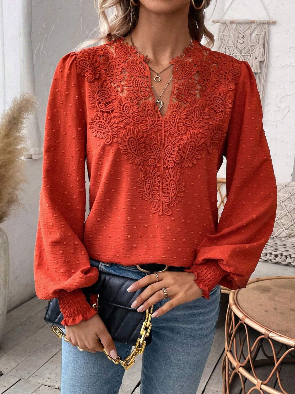 Orange-red embroidered yoke blouse with puff sleeves and textured fabric.