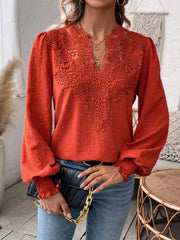 Orange-red embroidered yoke blouse with puff sleeves and textured fabric.