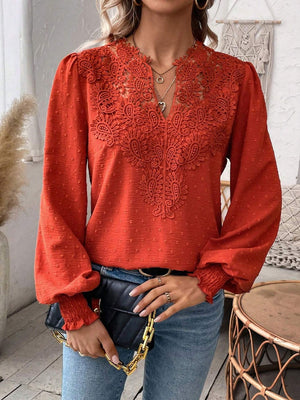 Orange-red embroidered yoke blouse with puff sleeves and textured fabric.