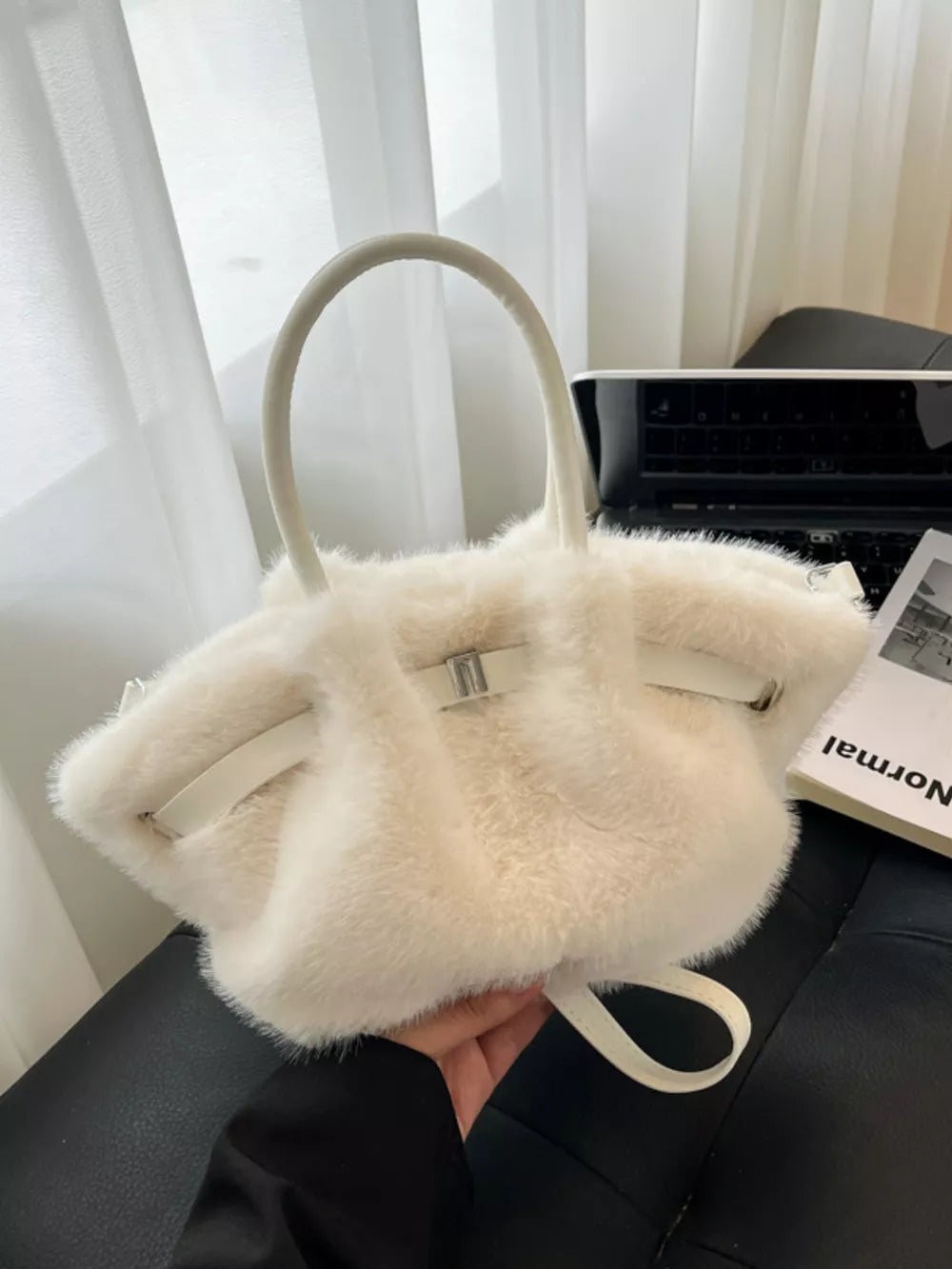 Plush crossbody bag in white with chic buckle detail and leather straps.