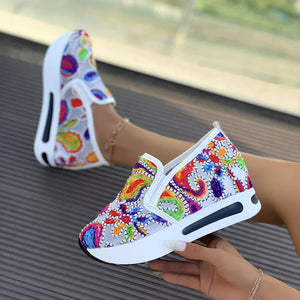 White paisley print platform slip-on shoes with chunky sole and colorful embroidery.