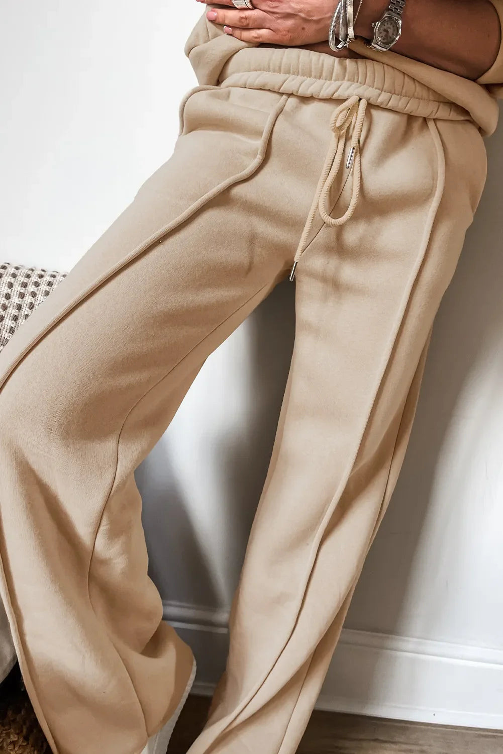 Tan seamed jogger pants with drawstring waist and cuffed ankles.