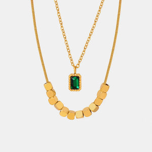 Gold layered necklace with emerald cube pendant and gold bead accent