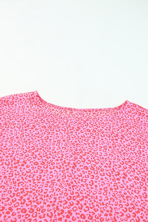 Pink leopard print blouse with smocked sleeves and a round neckline.