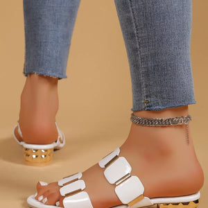White block heel sandals with gold accent straps and a textured gold heel.