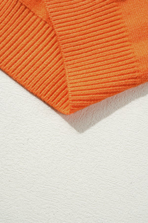 Orange knit sweater detail with ribbed texture and a subtle chevron pattern.