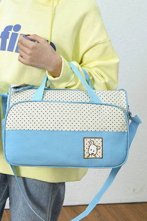 Pastel blue and white polka dot diaper bag with a cute bear applique.