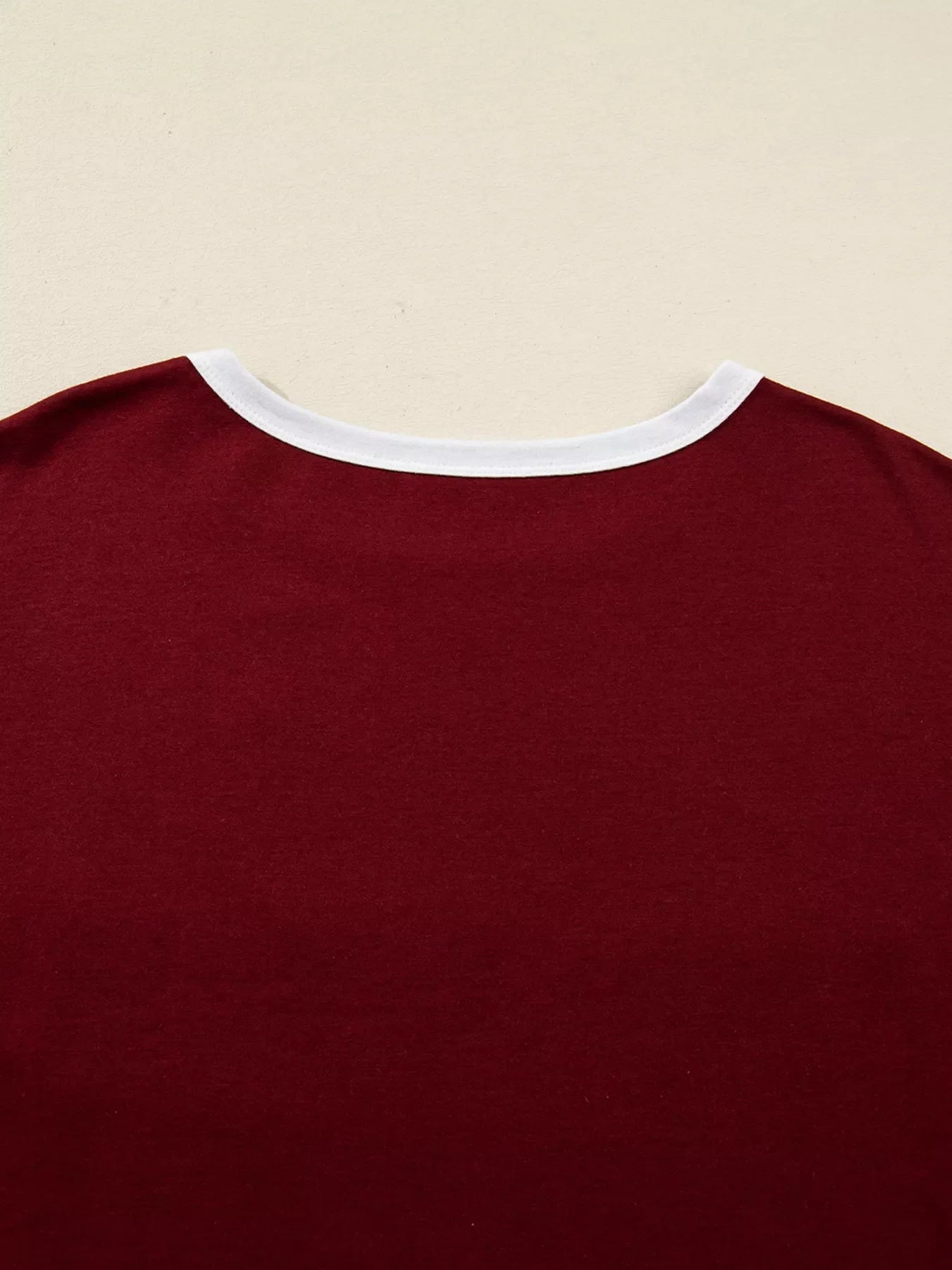 Burgundy long-sleeve top with white trim neckline.
