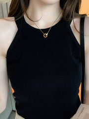 Black ribbed knit cami tank top with a high neckline and a gold pendant necklace.