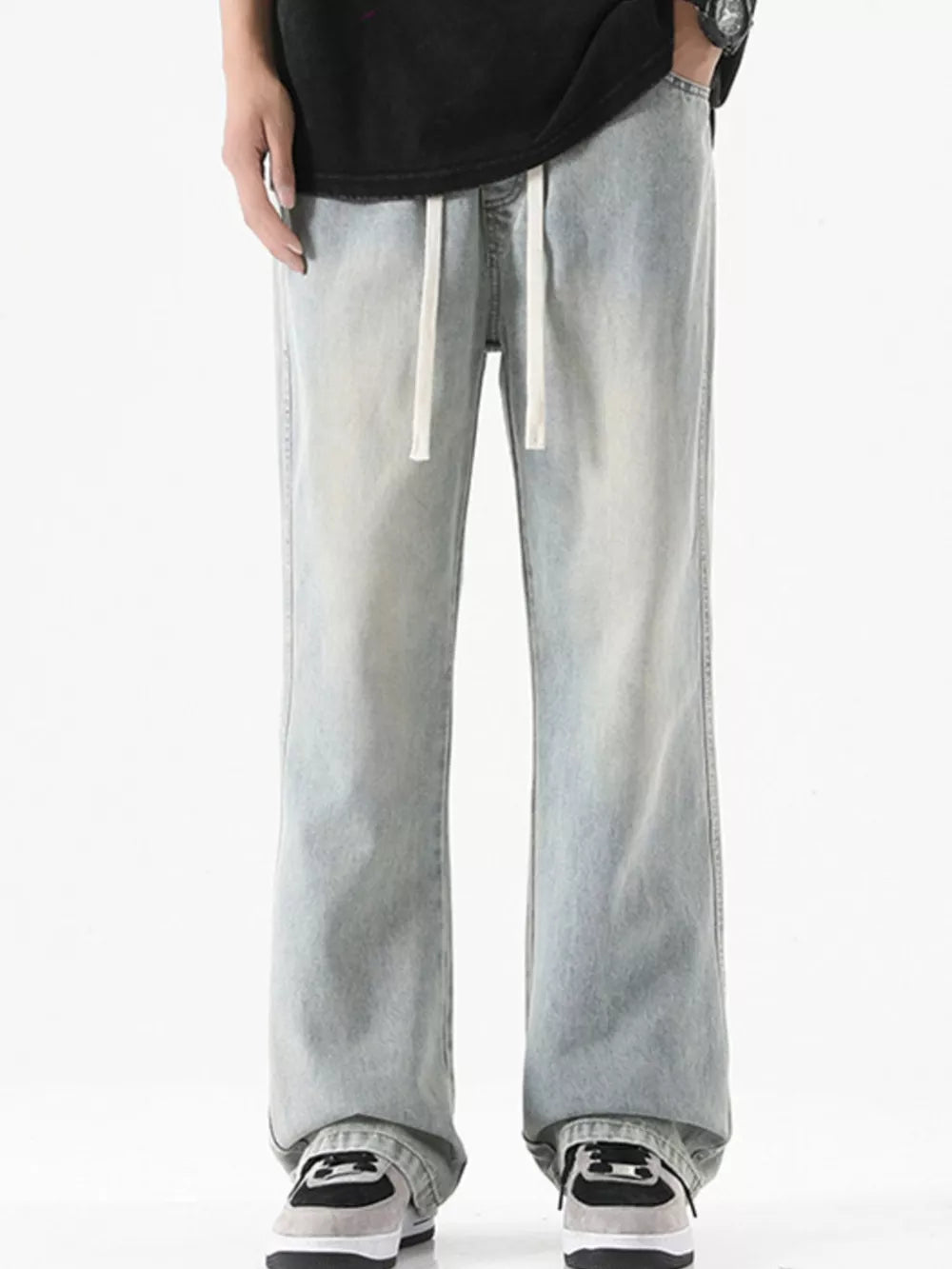 Men's light blue vintage wash drawstring jeans with a relaxed fit.