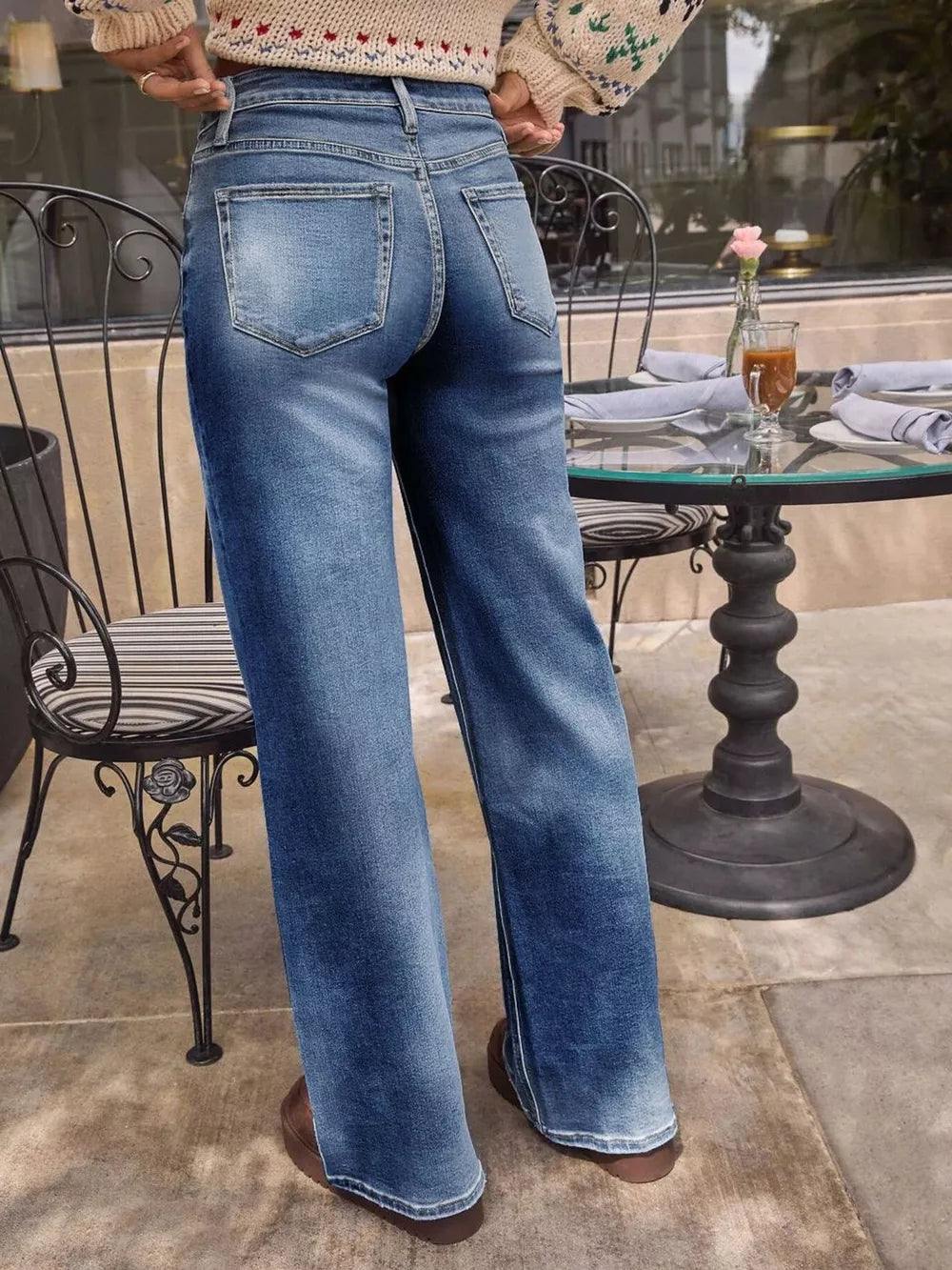 Light blue denim high-waisted wide-leg jeans with button fly and whiskering detail.
