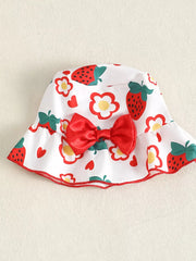 White baby bucket hat with strawberry and flower print, red bow detail.