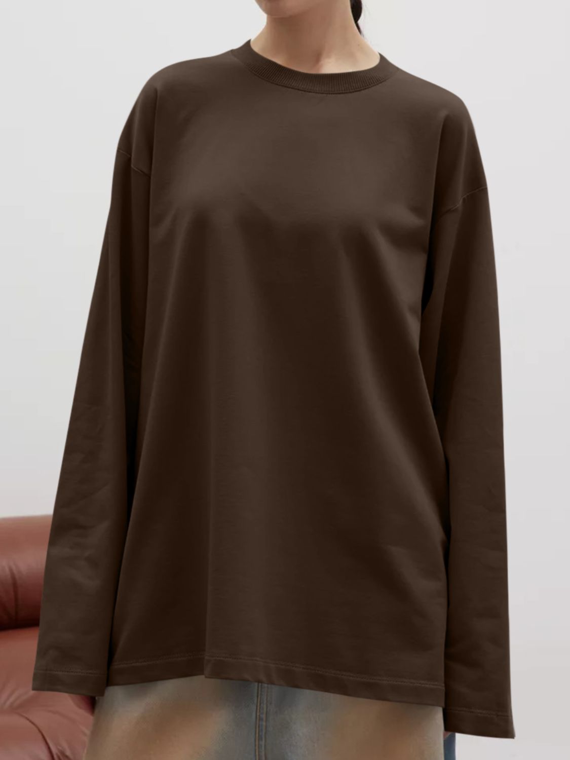Oversized crewneck sweatshirt in dark brown with voluminous long sleeves and a relaxed fit.