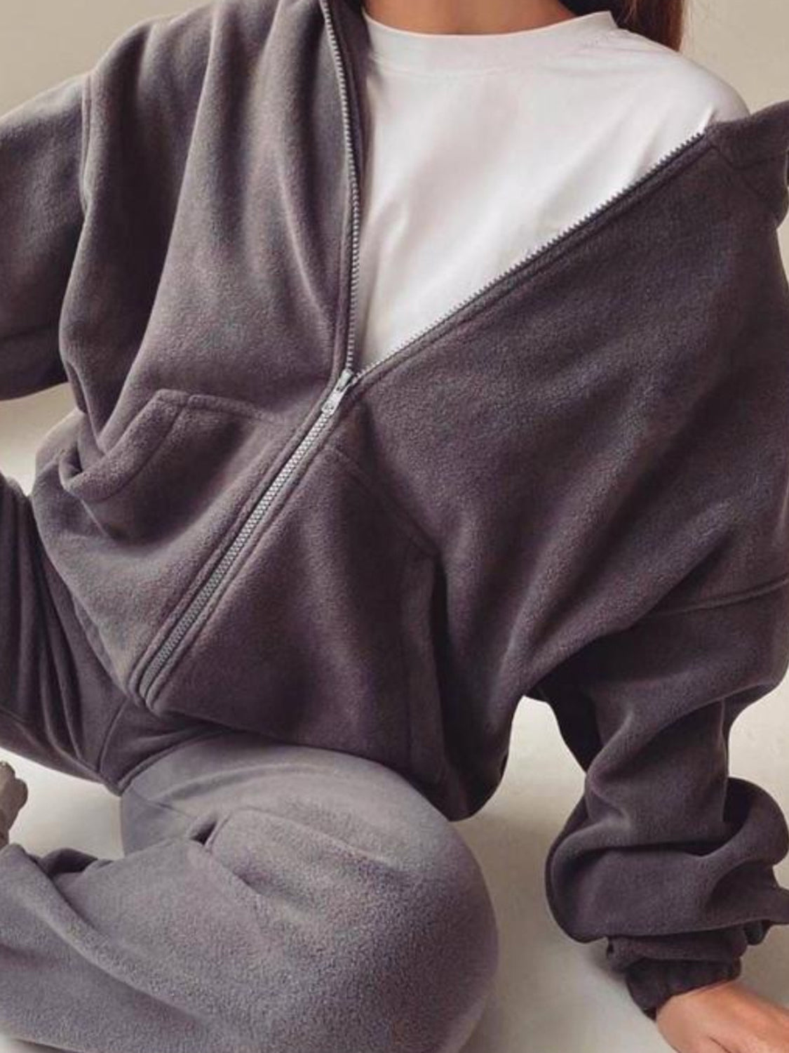 Dark Gray fleece zip-up hoodie with front pocket, worn over a white t-shirt.
