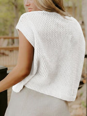 White acrylic knit short-sleeve sweater with open knit pattern and ribbed hem