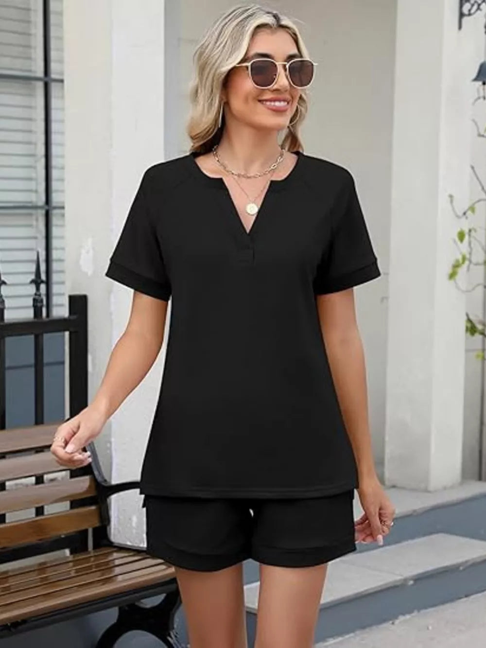 Black relaxed two-piece set with V-neck top and shorts, featuring pockets.