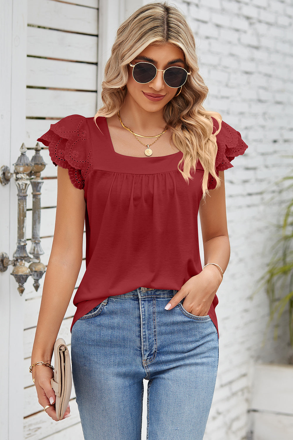 Rust eyelet flutter sleeve square neck blouse with ruffled detail.