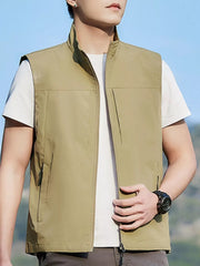 Khaki zip up vest with stand collar and zippered pockets, worn over a white t-shirt.