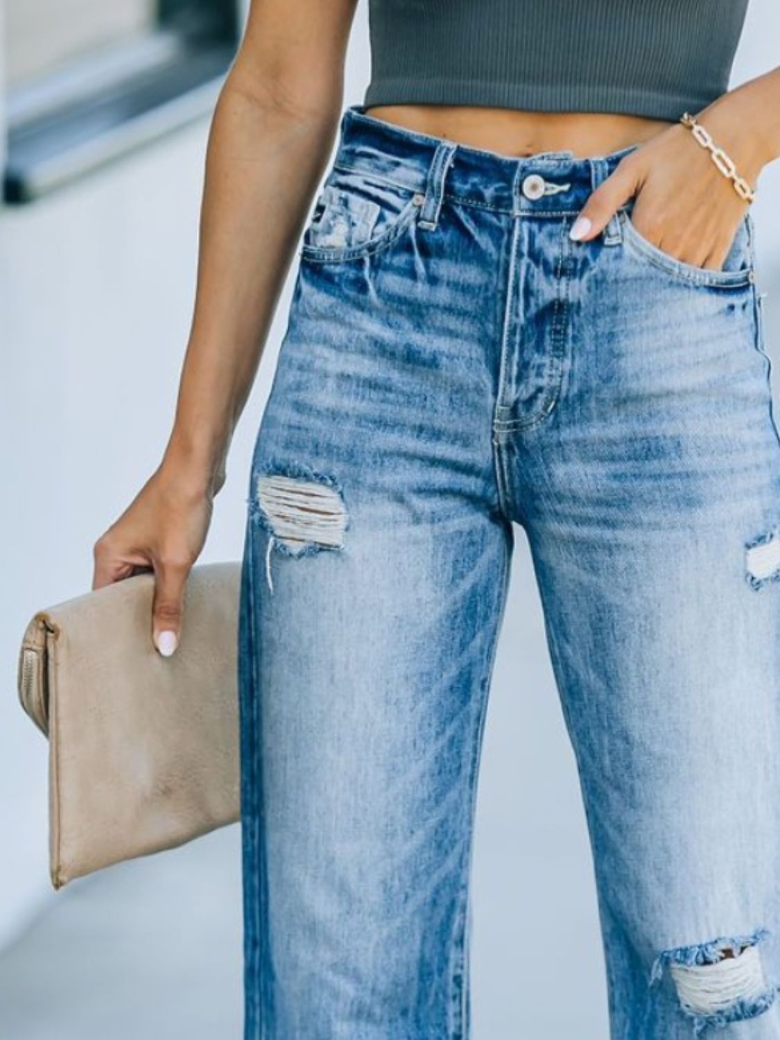 Wide-leg distressed denim jeans in dusty blue with a high rise, featuring ripped details.