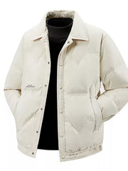 Ivory padded puffer jacket with button-down front and collar, worn over a black turtleneck.